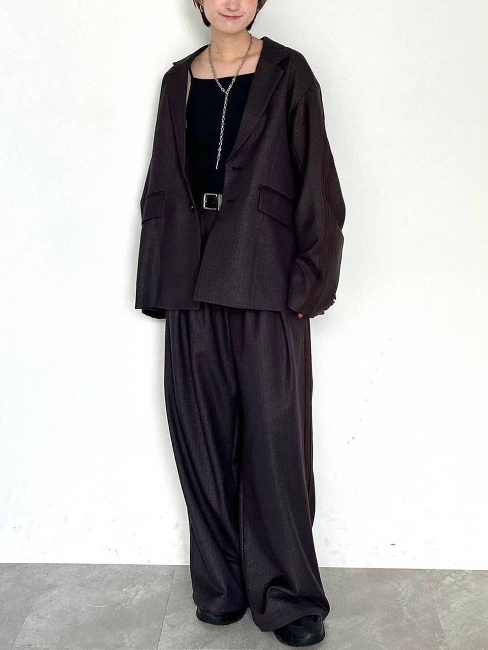 ブラウン系のスラックス、ブラウン系のテーラードジャケット、ブラック系のベルトを着用したレディースの秋コーディネートの2枚目の写真