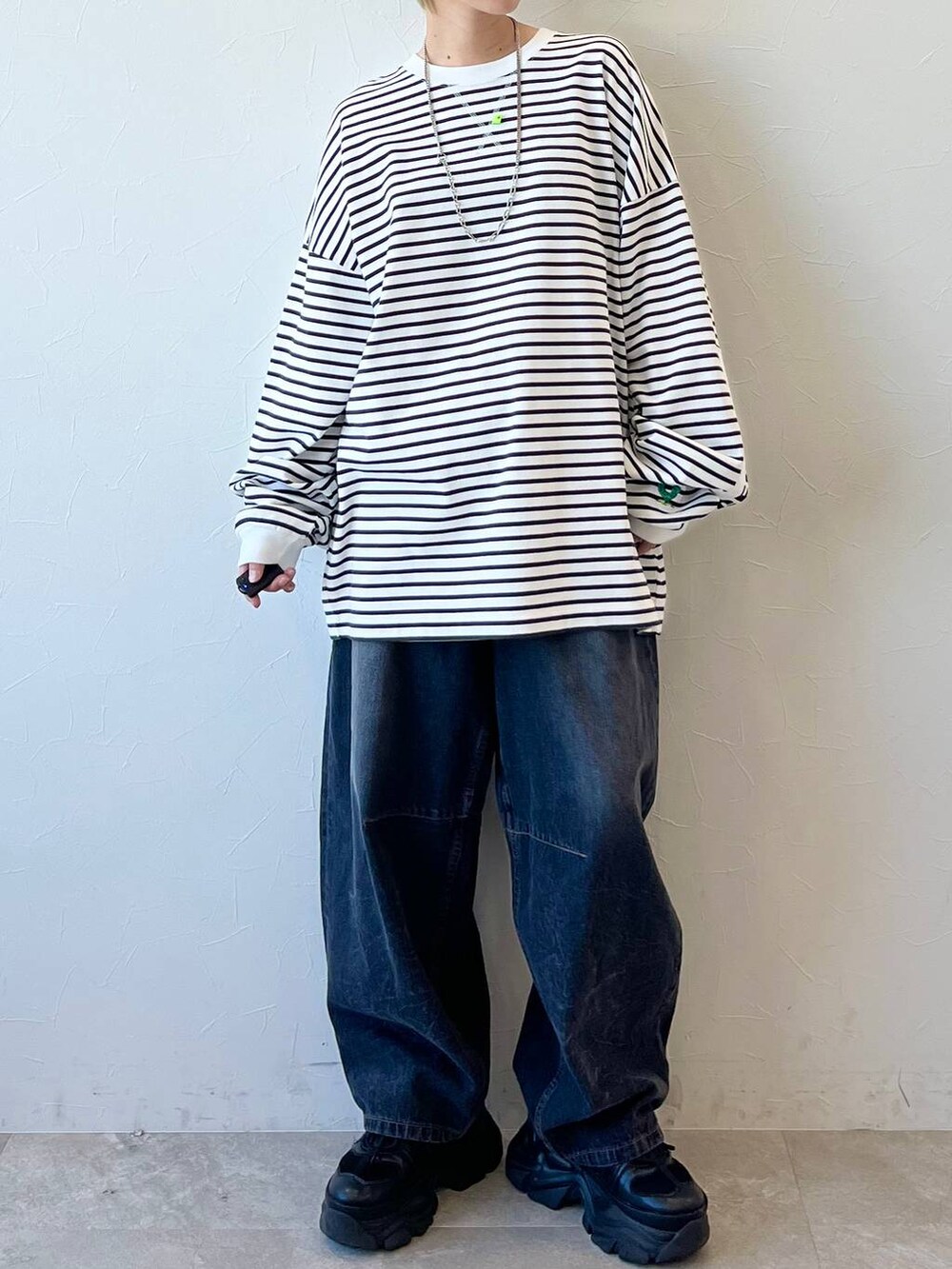 ブラック系のスニーカー、ブラック系のデニムパンツ、ブラック系のキャップを着用したレディースの春コーディネートの3枚目の写真