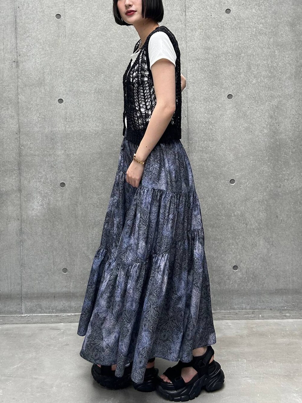 ブラック系のサンダル、ホワイト系のTシャツ/カットソー、ブラック系のスカートを着用したレディースの夏コーディネートの4枚目の写真