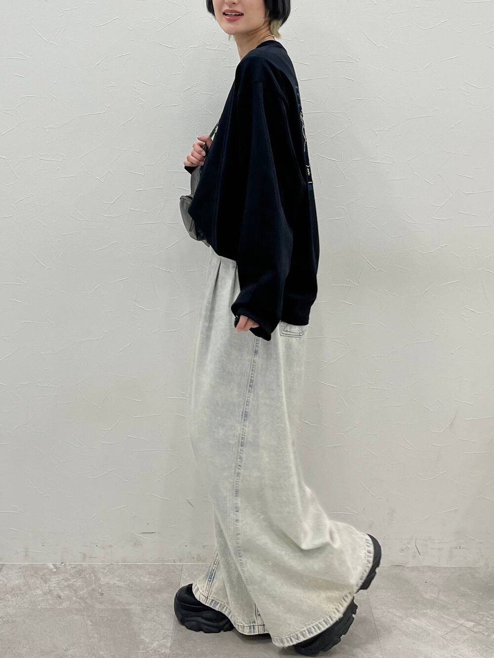 ブラック系のスニーカー、ブルー系のデニムパンツ、その他のショルダーバッグを着用したレディースの春コーディネートの8枚目の写真