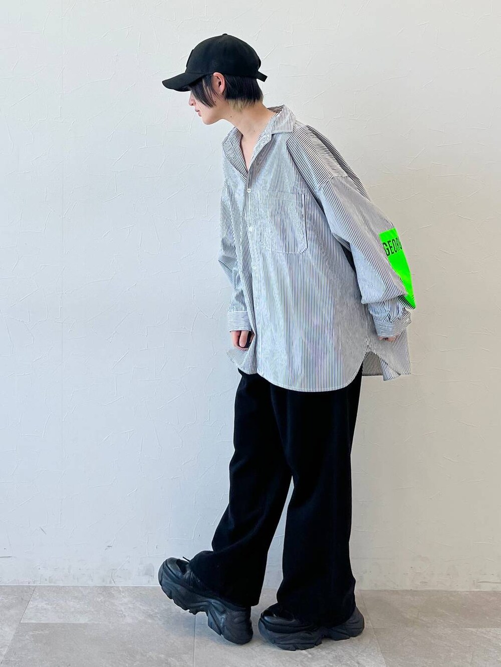 ブラック系のスニーカー、ブラック系のチノパンツ、ブラック系のキャップを着用したレディースの春コーディネートの3枚目の写真