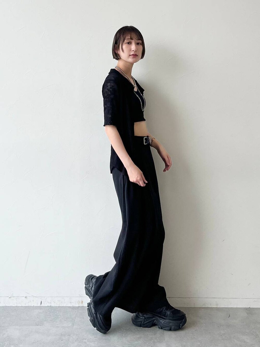 ブラック系のスニーカー、ブラック系のキャミソール、ブラック系のスラックスを着用したレディースの夏コーディネートの3枚目の写真