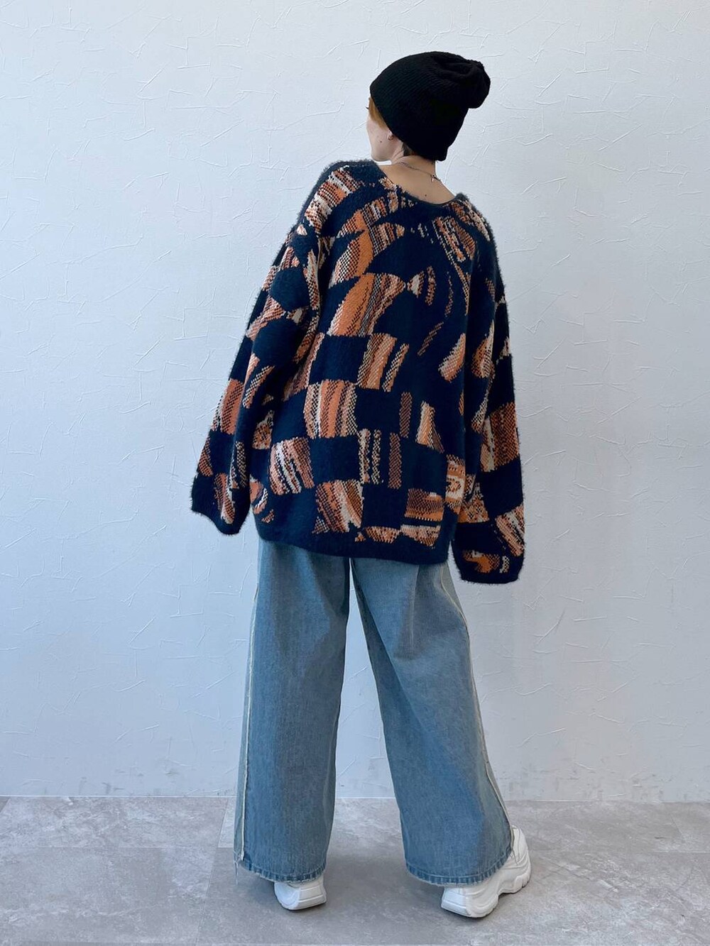 ブルー系のデニムパンツ、ブルー系のニット/セーター、ブラック系のニットキャップ/ビーニーを着用したレディースの秋コーディネートの4枚目の写真