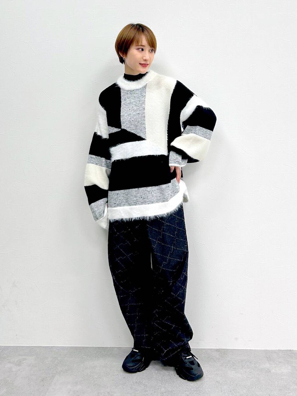 ブラック系のブルゾン、ブラック系のデニムパンツを着用したレディースの春コーディネートの2枚目の写真