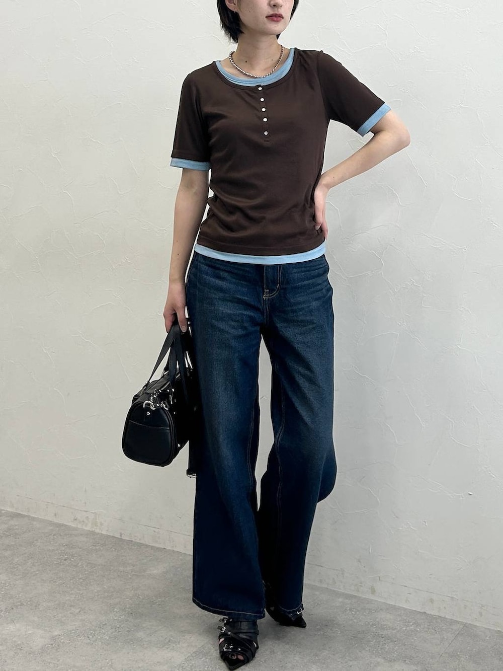 ブルー系のデニムパンツ、ブラック系のサンダル、ブラウン系のTシャツ/カットソーを着用したレディースの春コーディネートの2枚目の写真