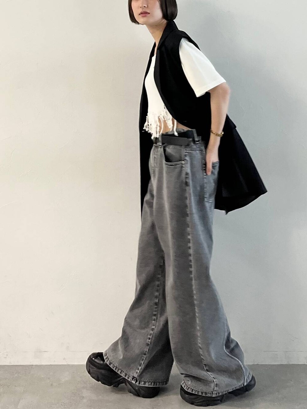 ブラック系のスニーカー、ブラック系のデニムパンツ、ブラック系のその他アウターを着用したレディースの春コーディネートの4枚目の写真