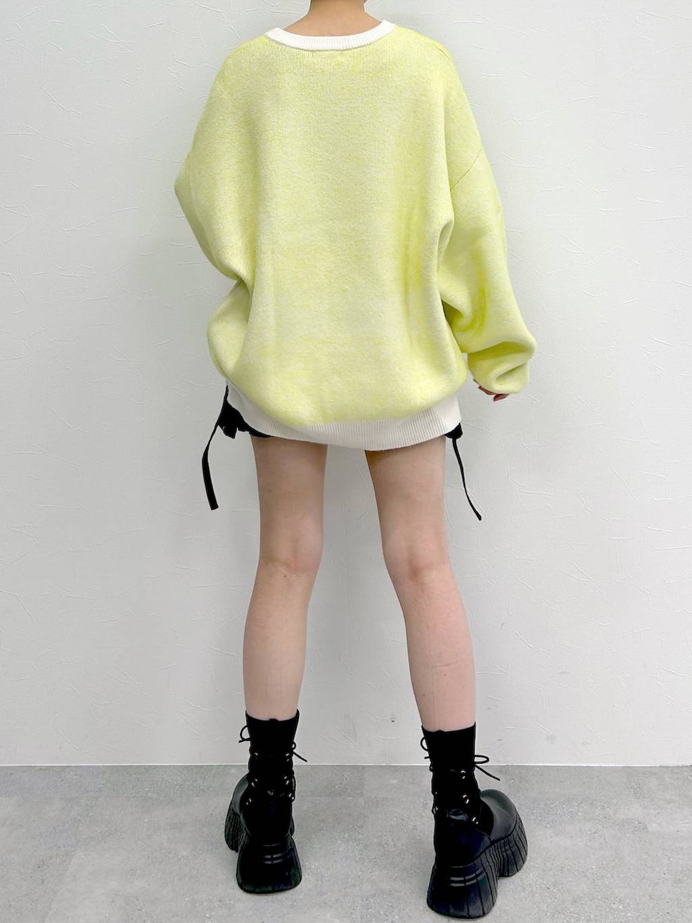 ホワイト系のニット/セーター、ブラック系のブーツ、ブラック系のスカートを着用したレディースの冬コーディネートの8枚目の写真