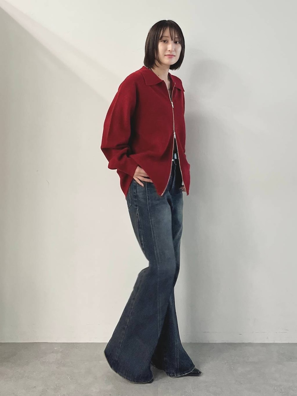 ブラック系のキャミソール、ブルー系のデニムパンツ、ブラック系のパンプスを着用したレディースの秋コーディネートの6枚目の写真