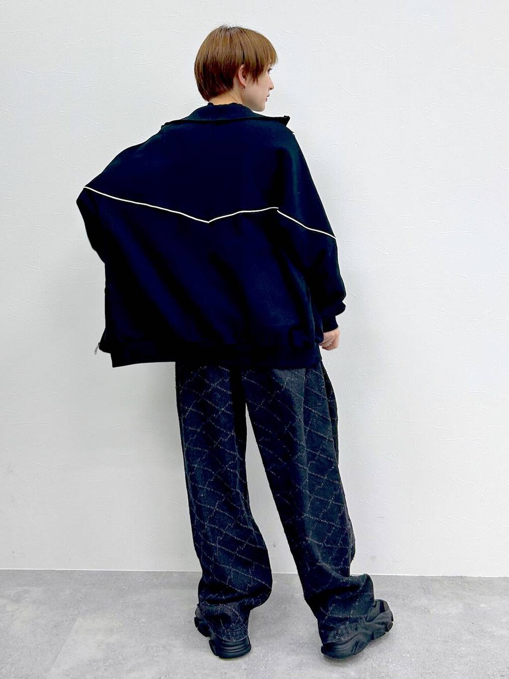 ブラック系のスウェット、ブラック系のデニムパンツ、ブラック系のベルトを着用したレディースの冬コーディネートの8枚目の写真