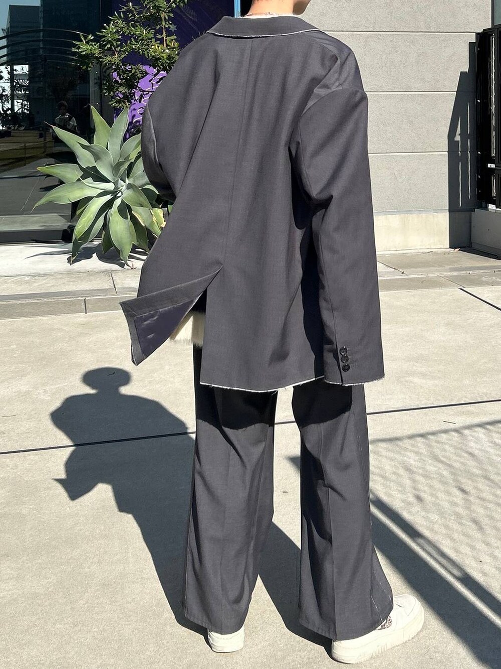 グレー系のスラックス、グレー系のテーラードジャケット、ブルー系のニット/セーターを着用したレディースの冬コーディネートの7枚目の写真