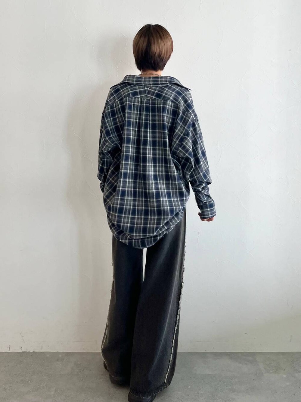 ブラック系のスニーカー、ブルー系のシャツ/ブラウス、ブラック系のデニムパンツを着用したレディースの秋コーディネートの7枚目の写真