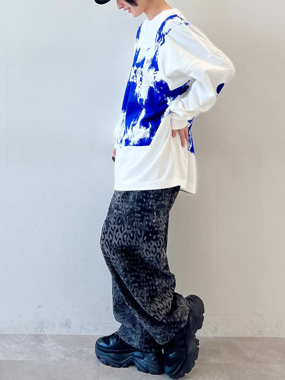 ブラック系のスニーカー、ブラック系のデニムパンツ、ブラック系のキャップを着用したレディースの春コーディネートの5枚目の写真