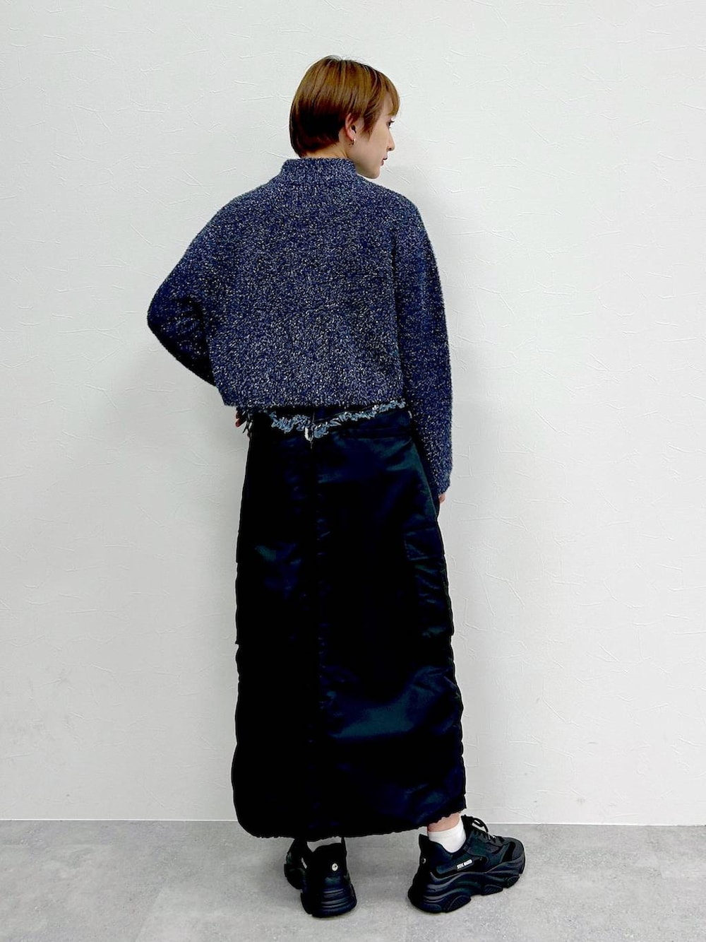 ブルー系のニット/セーター、ブラック系のスカートを着用したレディースの冬コーディネートの7枚目の写真