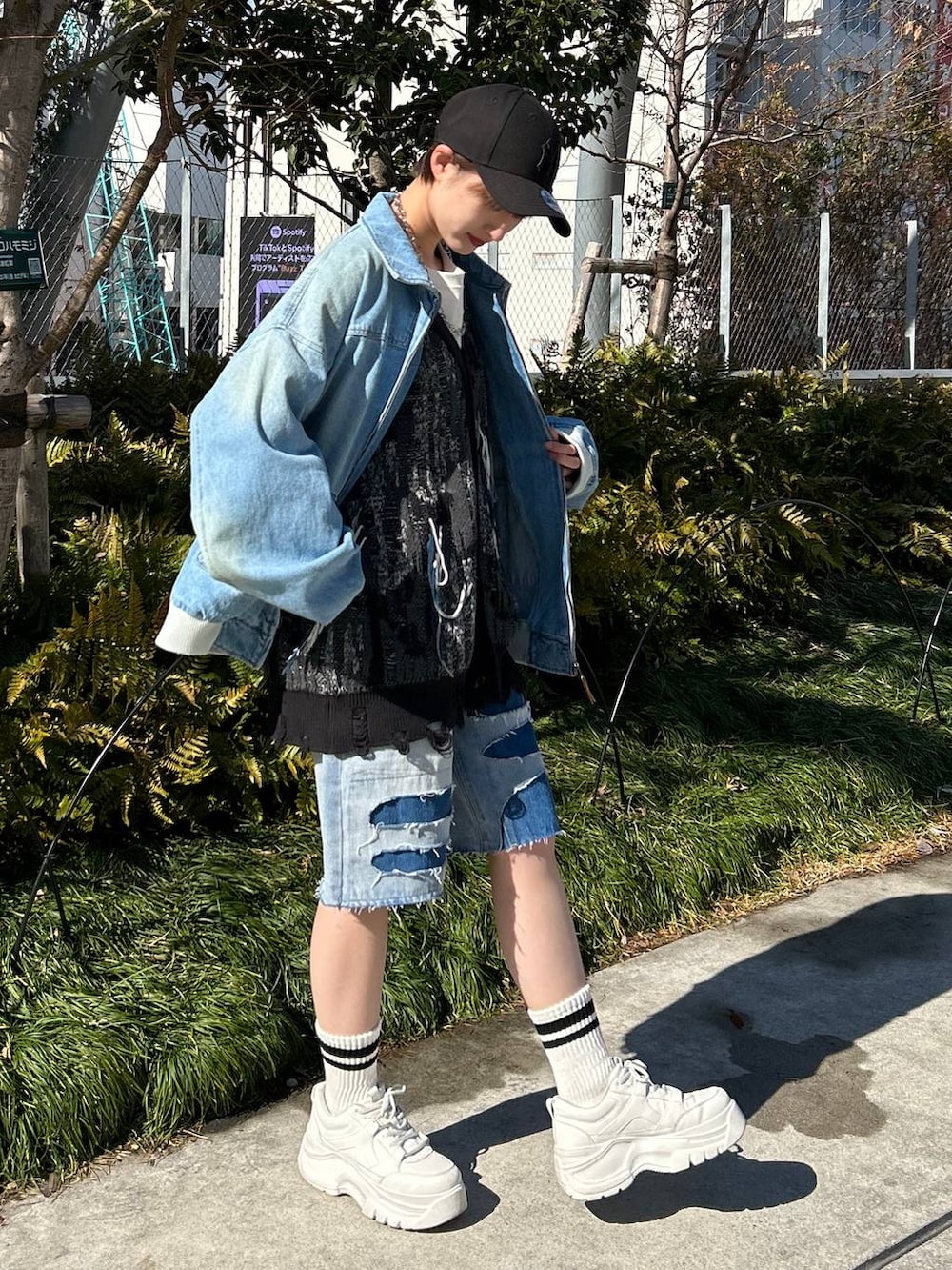 ブルー系のデニムジャケット、ブルー系のデニムパンツ、ブラック系のカーディガン/ボレロを着用したレディースの春コーディネートの3枚目の写真