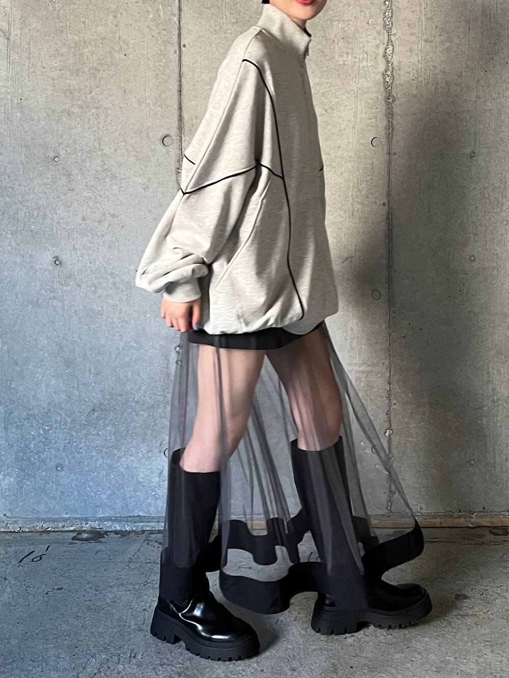 ブラック系のブーツ、グレー系のスウェット、グレー系のスカートを着用したレディースの冬コーディネートの4枚目の写真