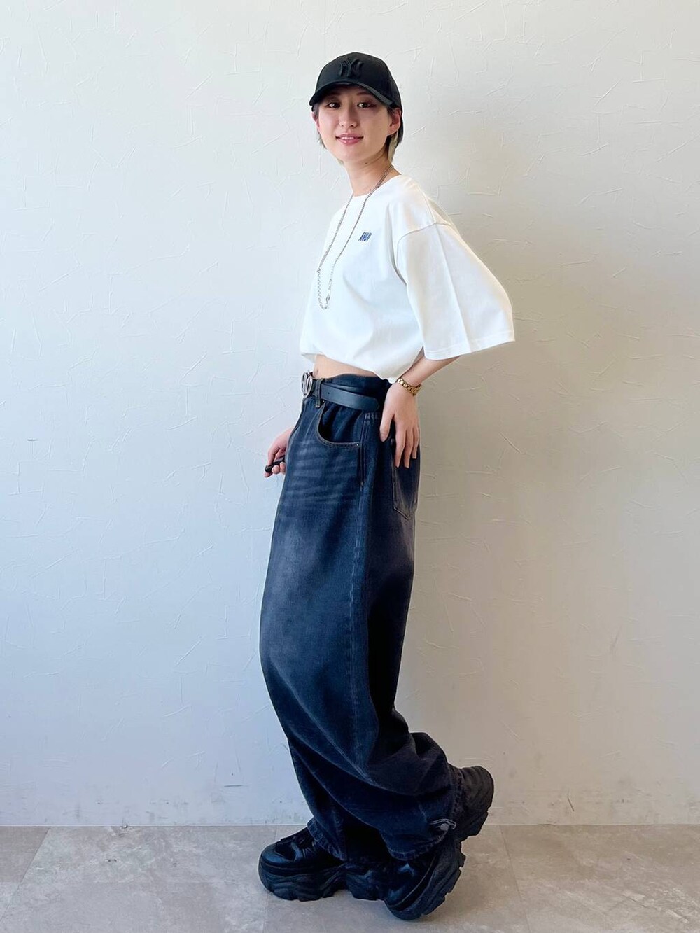 ブラック系のスニーカー、ブラック系のデニムパンツ、ホワイト系のTシャツ/カットソーを着用したレディースの春コーディネートの7枚目の写真