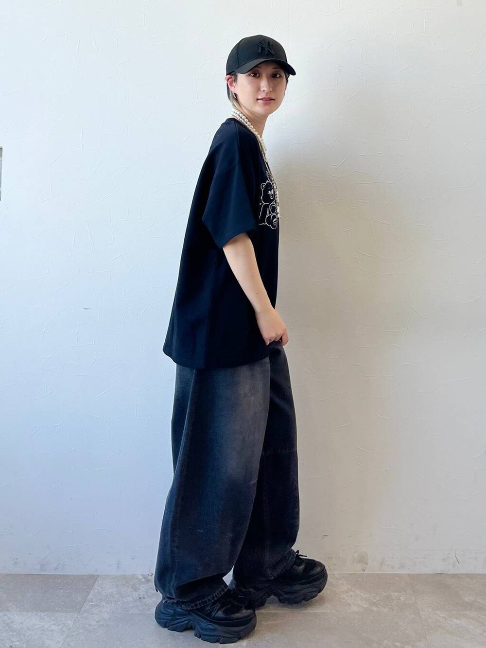 ブラック系のスニーカー、ブラック系のデニムパンツ、ブラック系のTシャツ/カットソーを着用したレディースの春コーディネートの3枚目の写真