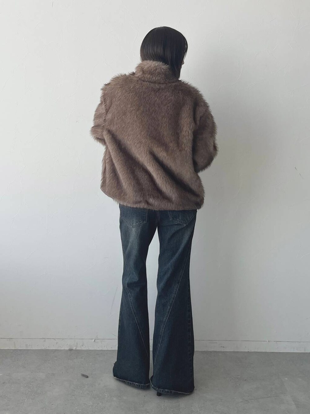 ブルー系のデニムパンツ、ブラック系のパンプスを着用したレディースの秋コーディネートの5枚目の写真