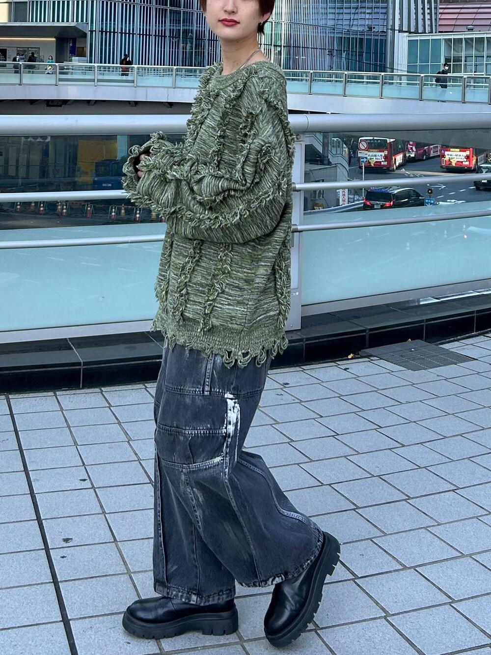 グリーン系のニット/セーター、ブラック系のデニムパンツを着用したレディースの冬コーディネートの4枚目の写真