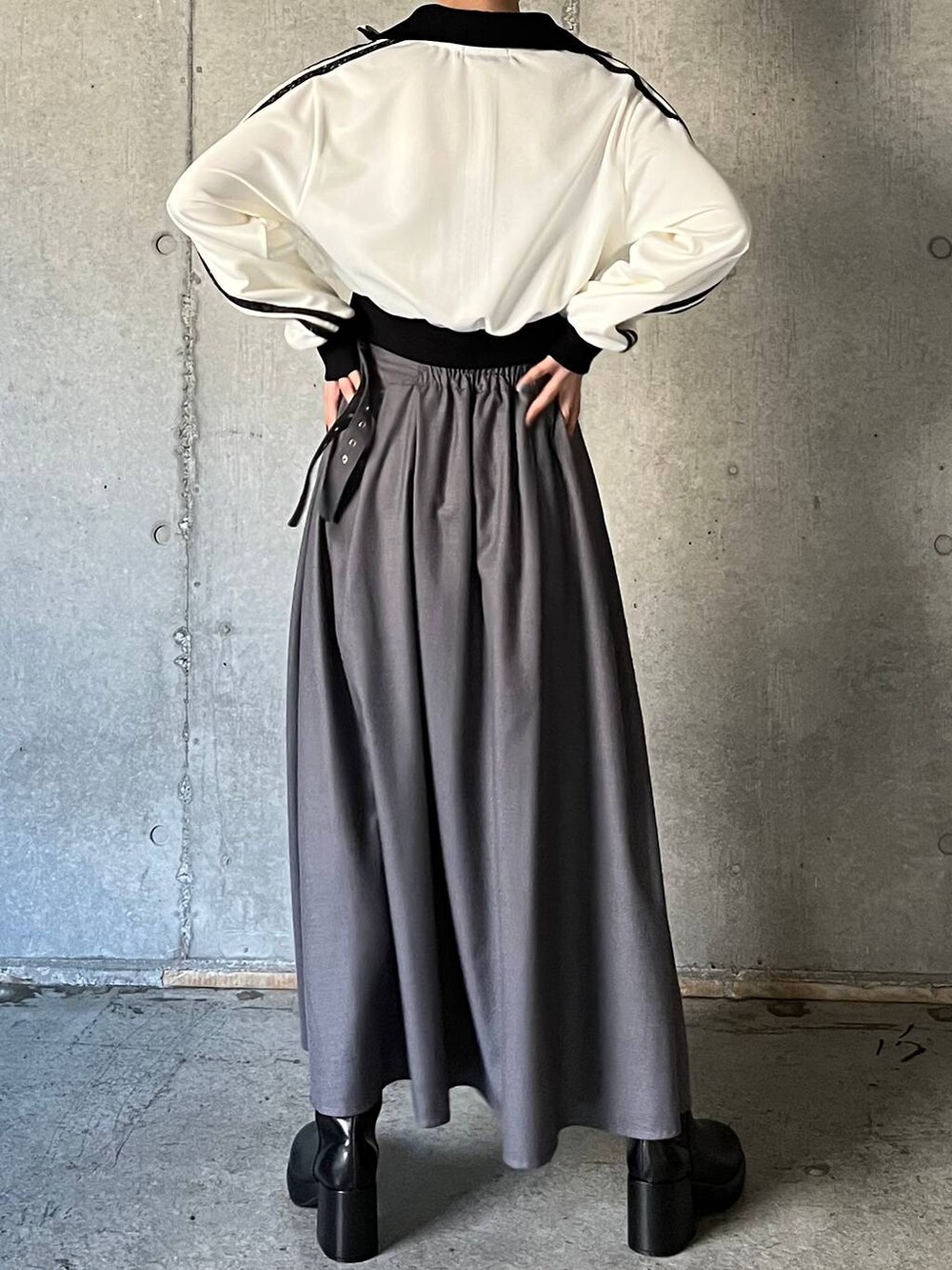 ブラック系のキャミソール、ブラック系のブーツ、グレー系のスカートを着用したレディースの冬コーディネートの6枚目の写真