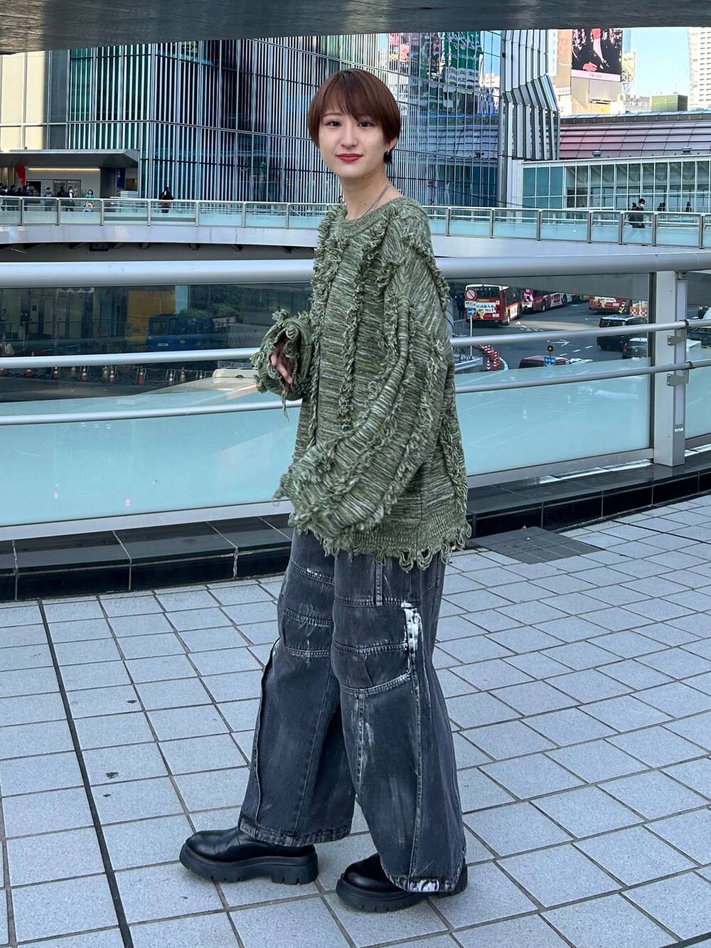 グリーン系のニット/セーター、ブラック系のデニムパンツを着用したレディースの冬コーディネートの3枚目の写真