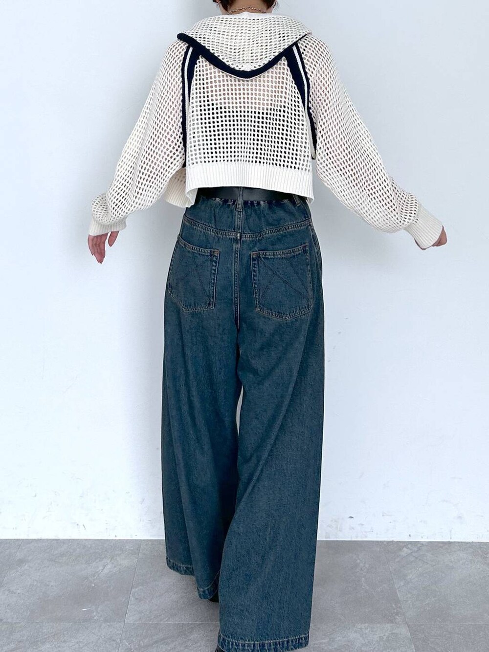 ブルー系のデニムパンツ、ホワイト系のパーカー、ブラック系のベルトを着用したレディースの夏コーディネートの5枚目の写真