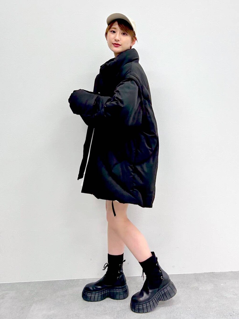 ブラック系のブルゾン、ブラック系のブーツ、ブラック系のスカートを着用したレディースの冬コーディネートの6枚目の写真