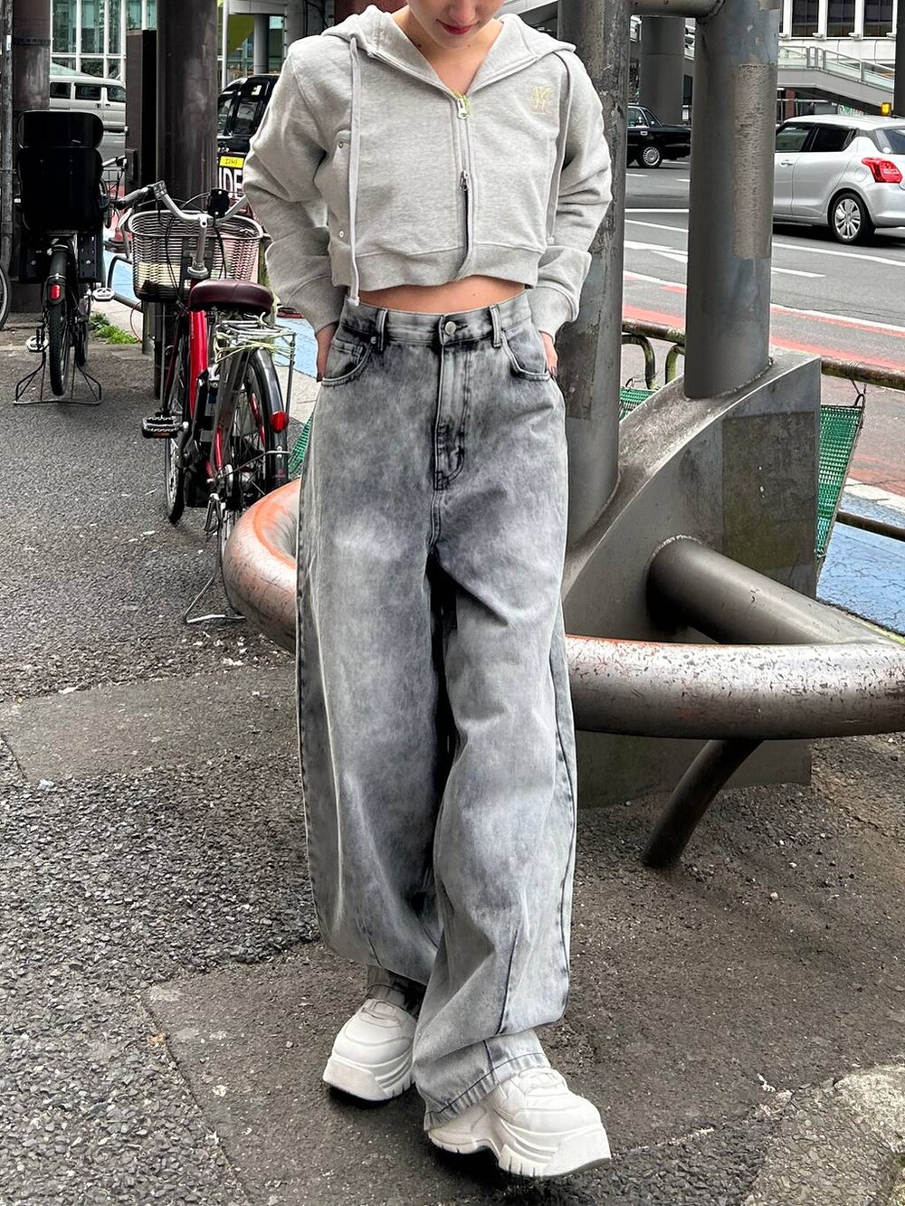 グレー系のパーカー、ブラック系のデニムパンツを着用したレディースの春コーディネートの2枚目の写真