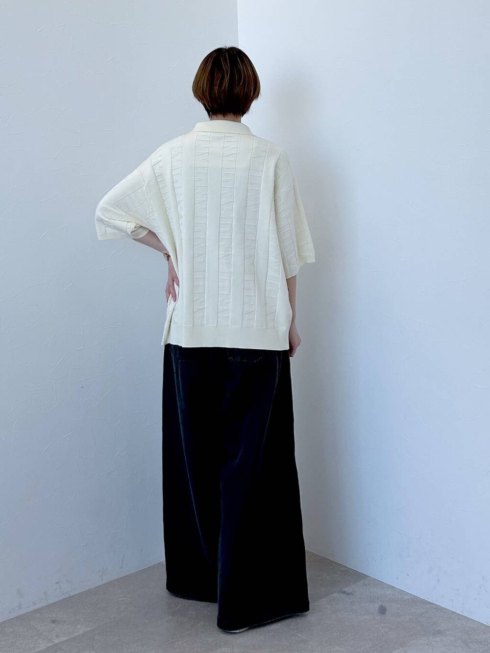 ホワイト系のニット/セーター、ブラック系のデニムパンツ、グレー系のネクタイを着用したレディースの春コーディネートの6枚目の写真