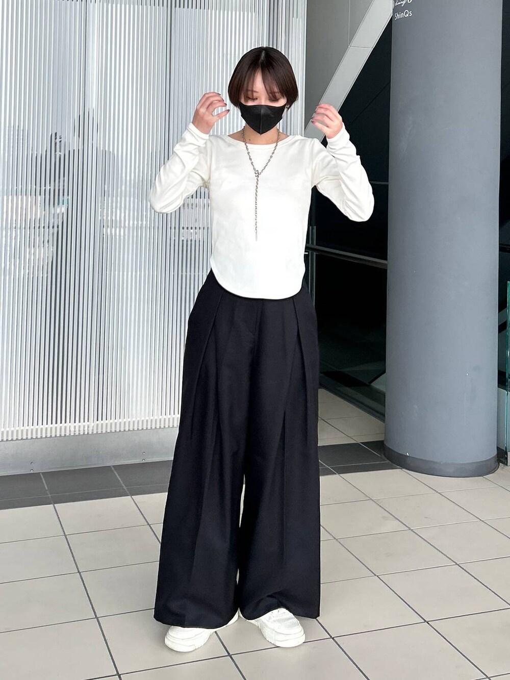 ホワイト系のTシャツ/カットソー、ブラック系のスラックス、シルバー系のネックレスを着用したレディースの春コーディネートの2枚目の写真