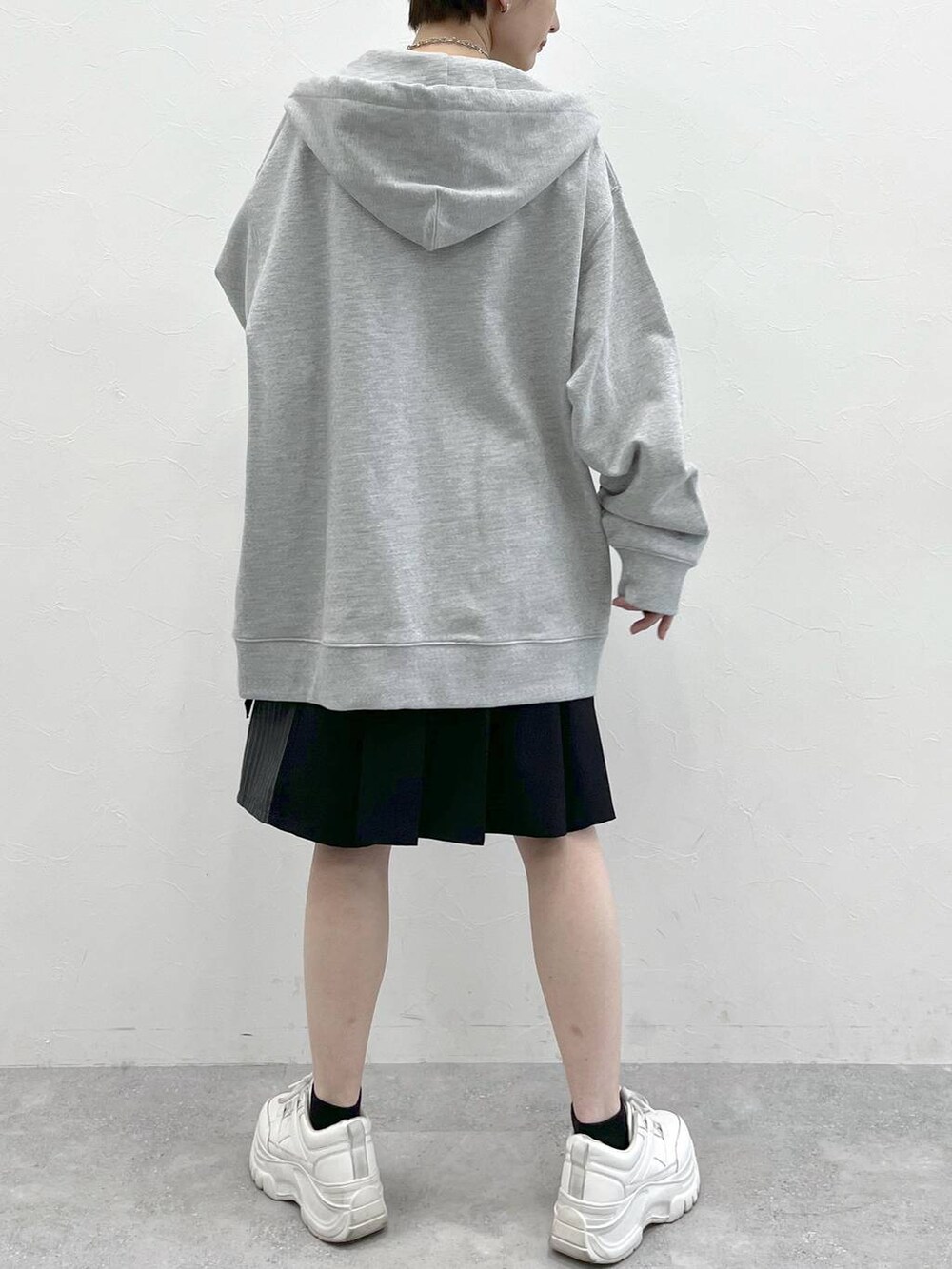 グレー系のパーカー、ブラック系のスラックスを着用したレディースの春コーディネートの8枚目の写真