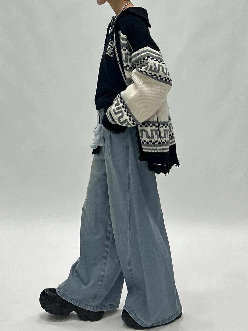 ブルー系のデニムパンツ、ブラック系のブーツ、ブラック系のスウェットを着用したレディースの秋コーディネートの3枚目の写真