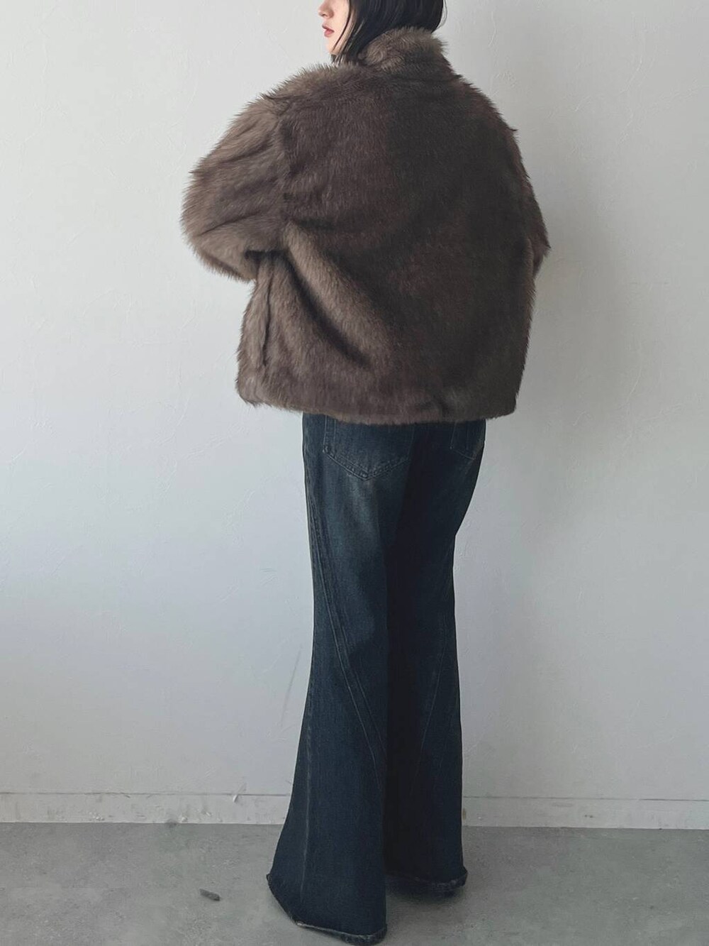 ブルー系のデニムパンツ、ブラック系のパンプスを着用したレディースの秋コーディネートの6枚目の写真