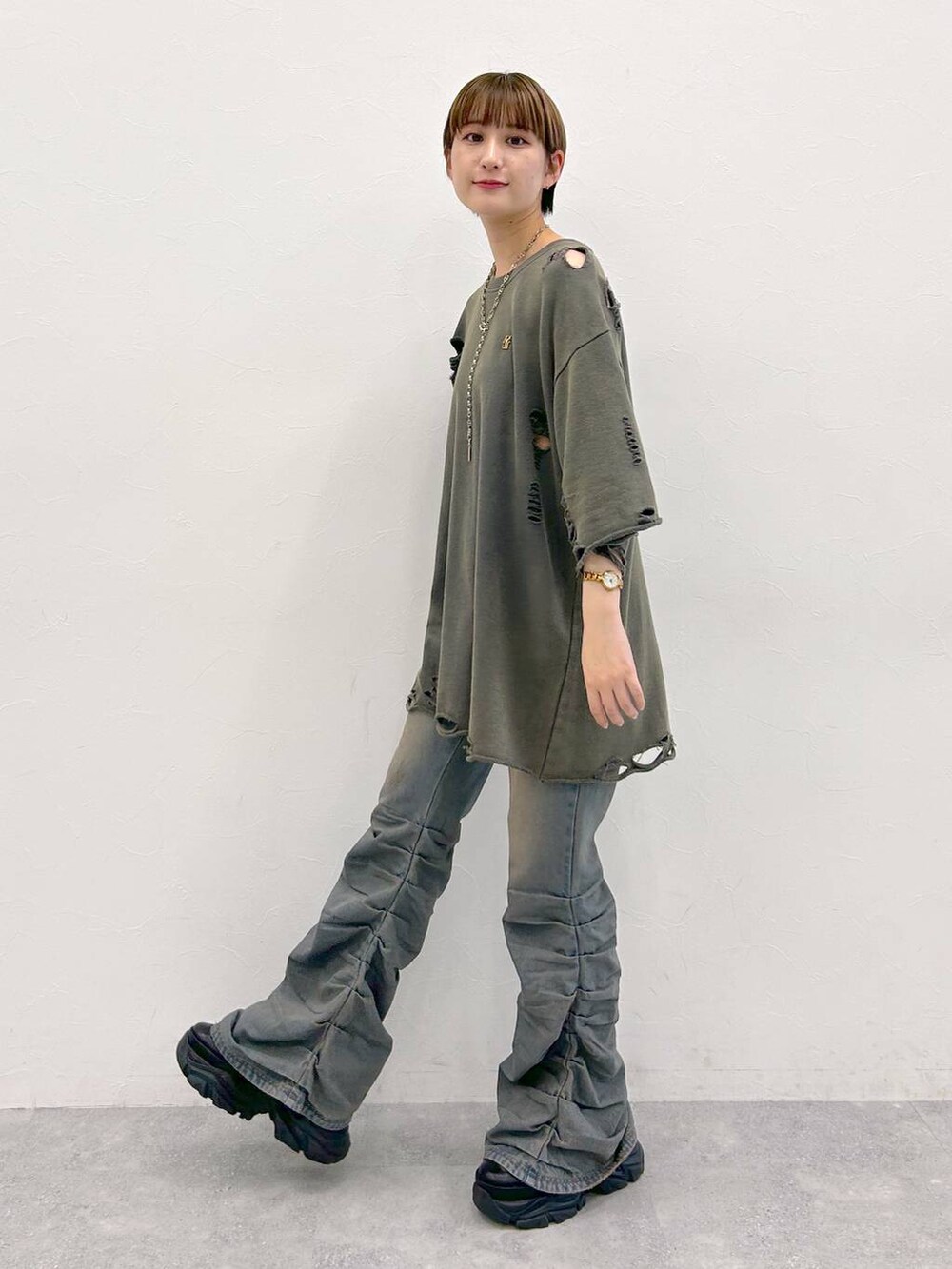 ブラック系のスニーカー、グレー系のTシャツ/カットソー、ブルー系のデニムパンツを着用したレディースの夏コーディネートの3枚目の写真