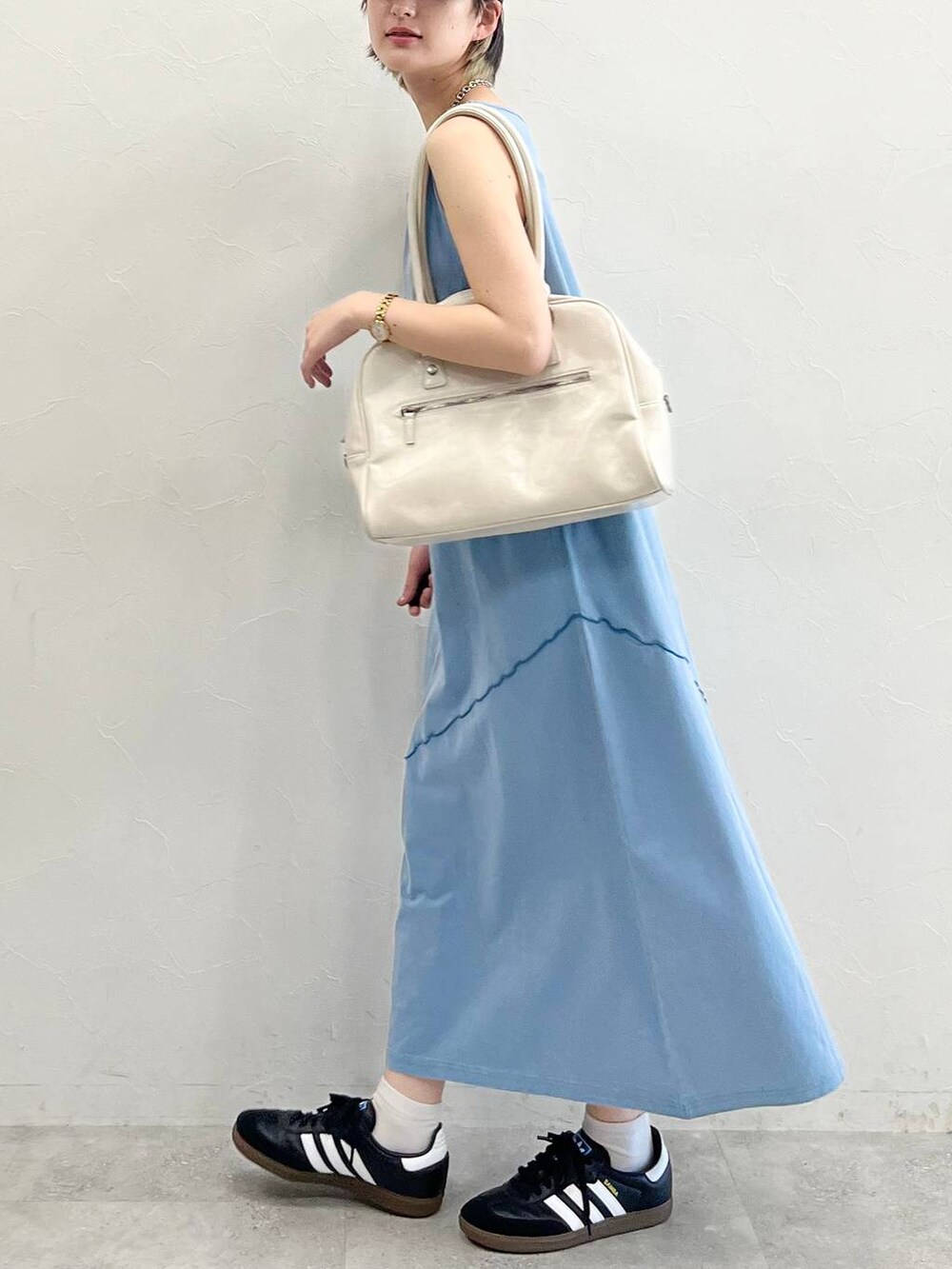ホワイト系のボストンバッグ、ブラック系のスニーカー、ブルー系のワンピースを着用したレディースの春コーディネートの4枚目の写真