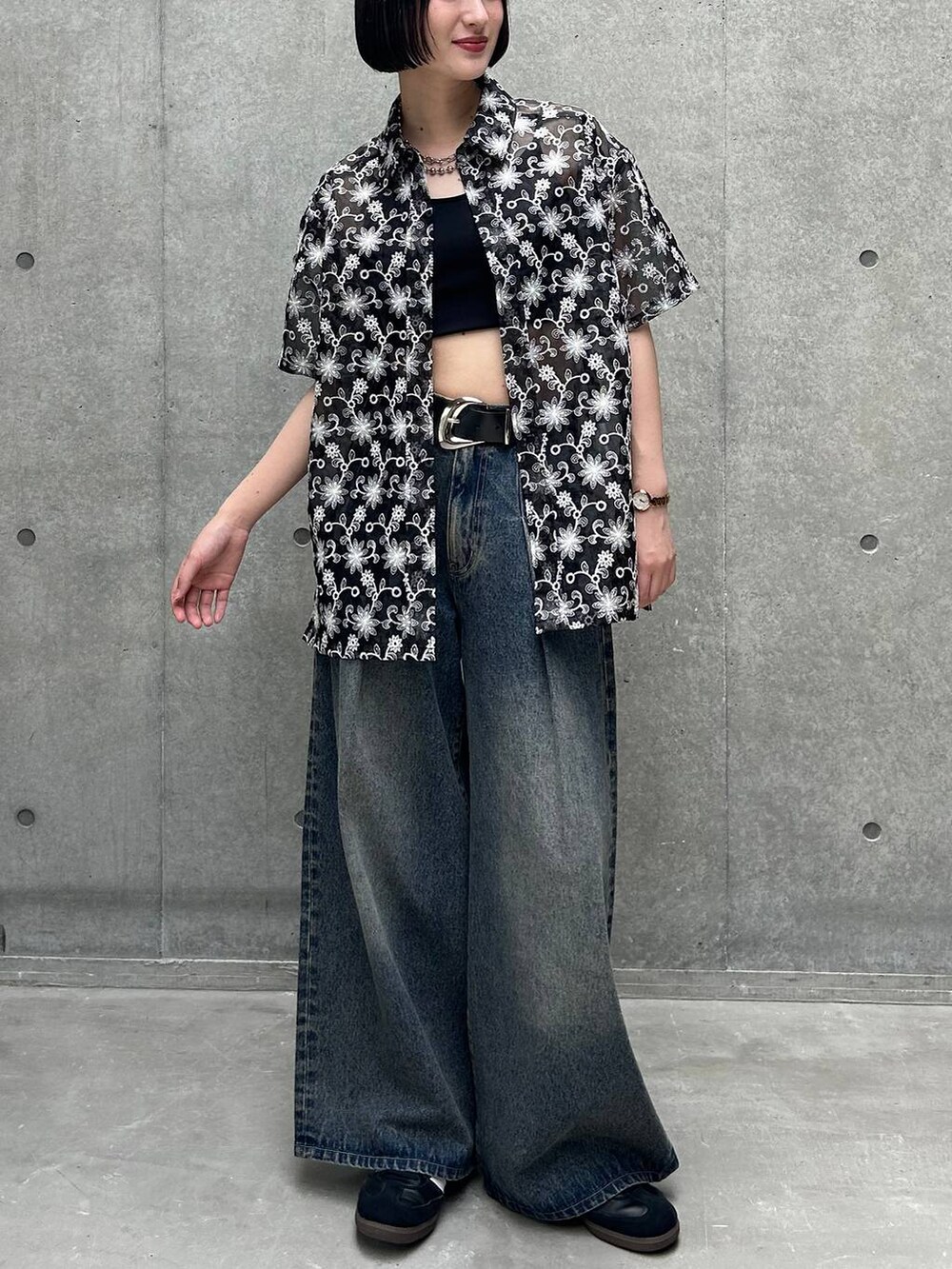 ブルー系のデニムパンツ、ブラック系のスニーカー、ブラック系のキャミソールを着用したレディースの夏コーディネートの3枚目の写真