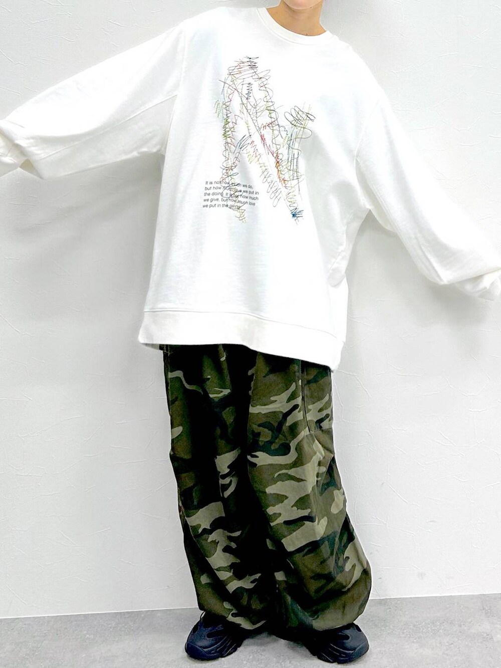 グリーン系のその他パンツ、ホワイト系のスウェット、ブラック系のキャップを着用したレディースの冬コーディネートの2枚目の写真