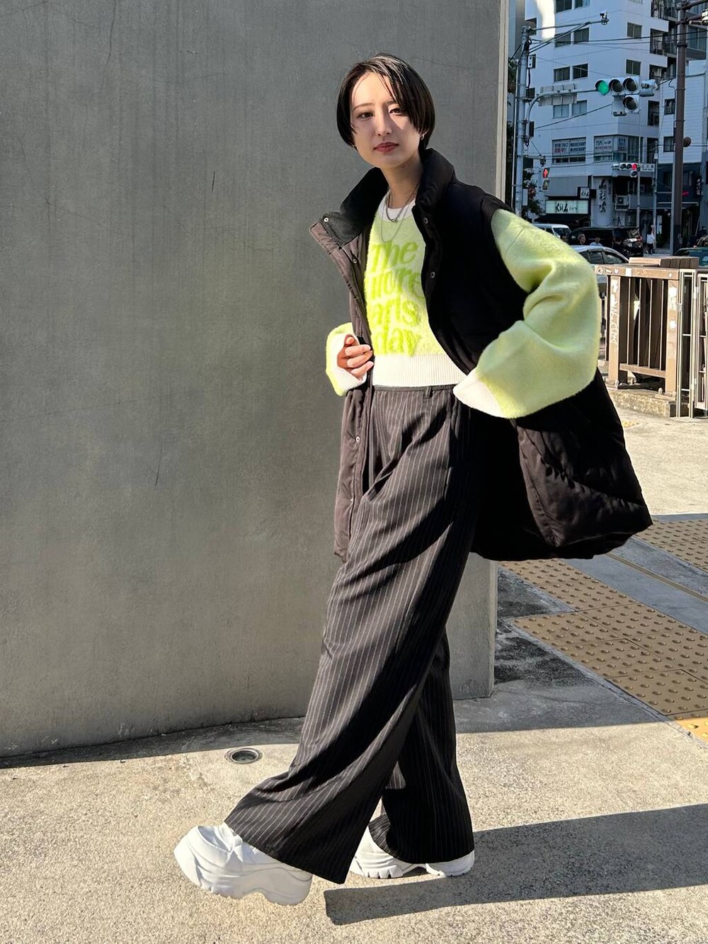 ブラック系のスラックス、ホワイト系のニット/セーター、ブラック系のブルゾンを着用したレディースの冬コーディネートの5枚目の写真