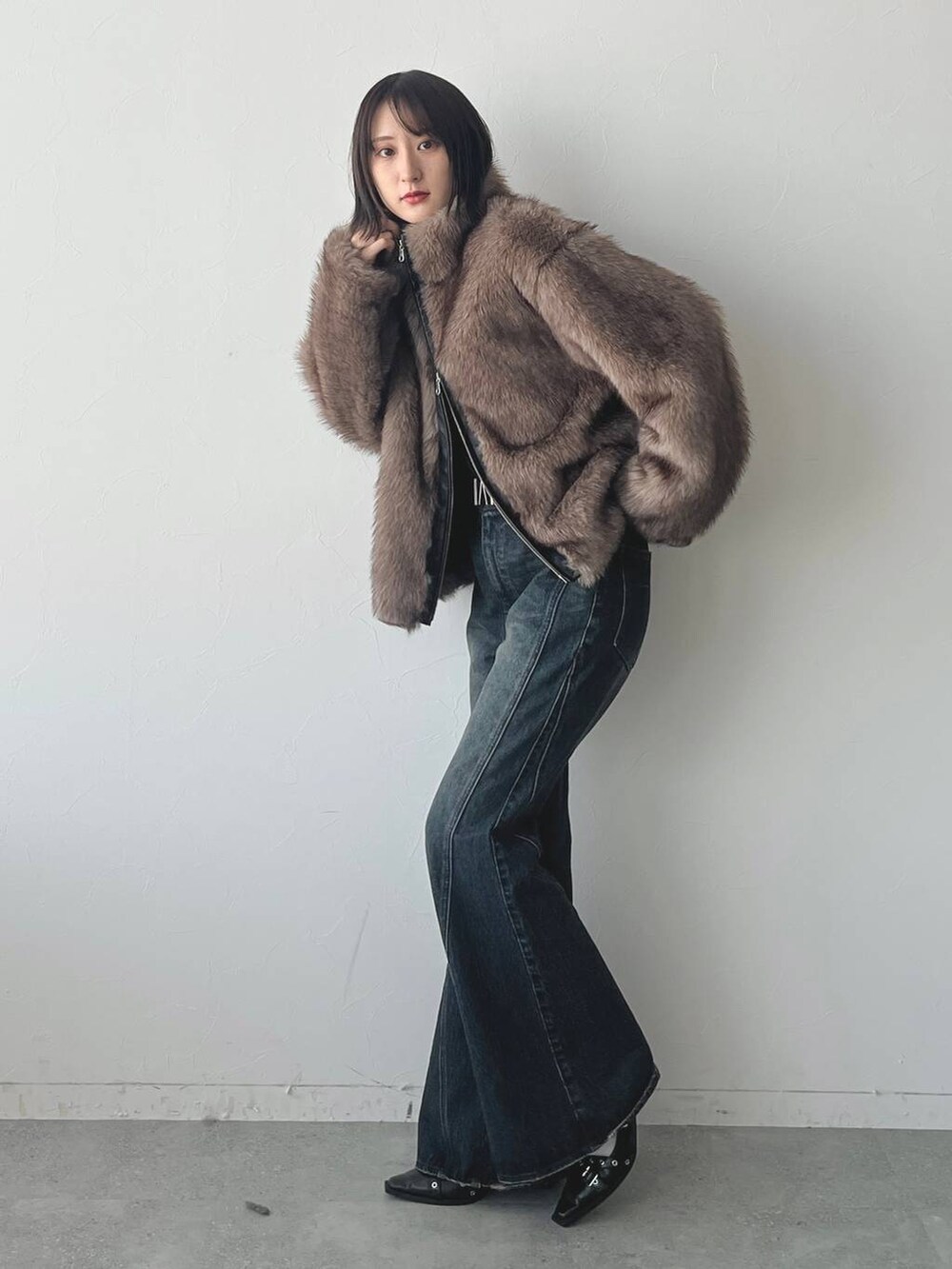 ブルー系のデニムパンツ、ブラック系のパンプスを着用したレディースの秋コーディネートの3枚目の写真