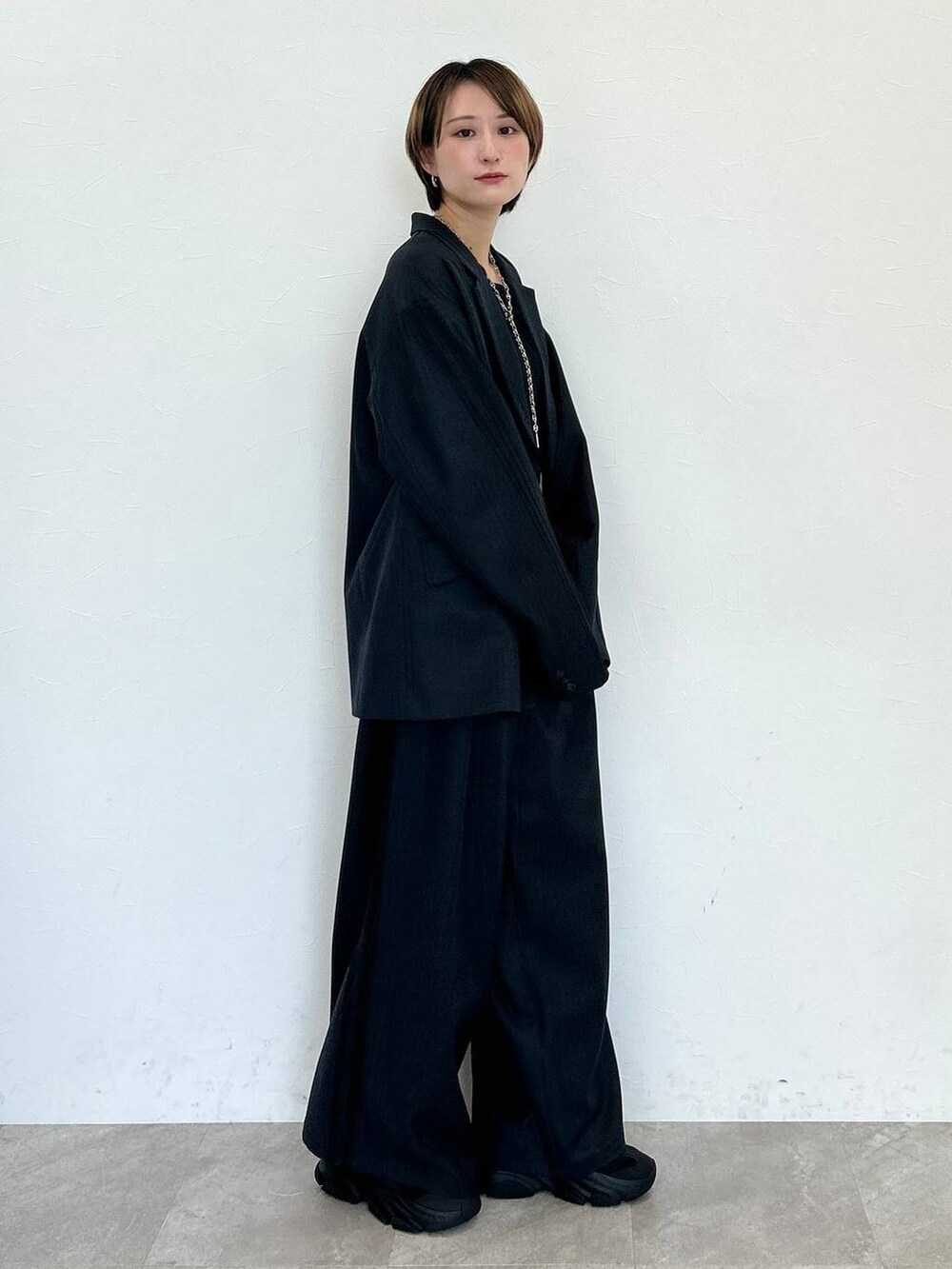 ブラック系のスラックス、ブラック系のテーラードジャケット、ブラック系のベルトを着用したレディースの秋コーディネートの5枚目の写真