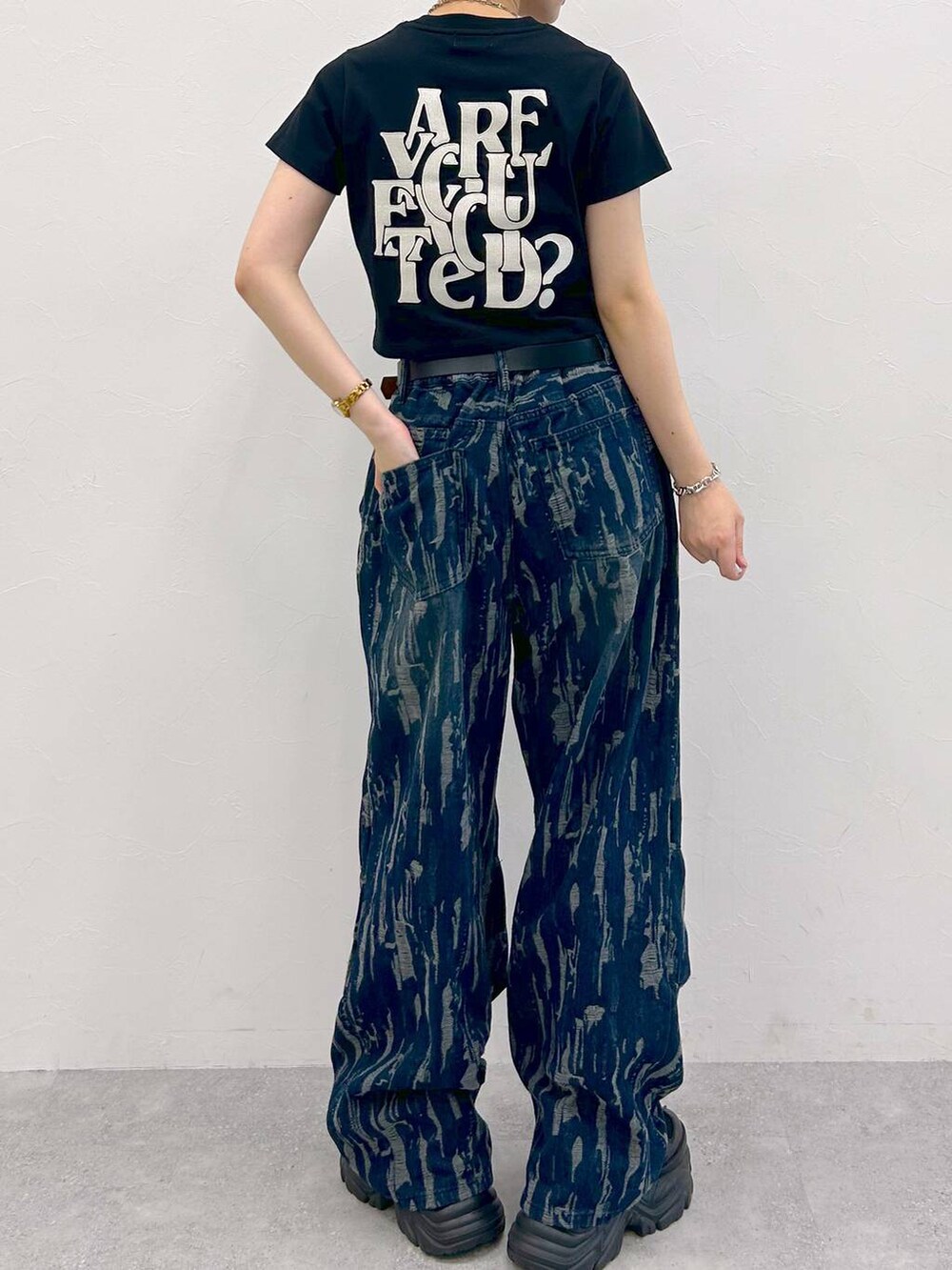 ブラック系のスニーカー、ブラック系のTシャツ/カットソー、ブルー系のデニムパンツを着用したレディースの夏コーディネートの9枚目の写真