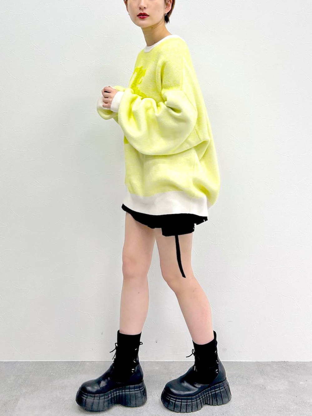 ホワイト系のニット/セーター、ブラック系のブーツ、ブラック系のスカートを着用したレディースの冬コーディネートの4枚目の写真