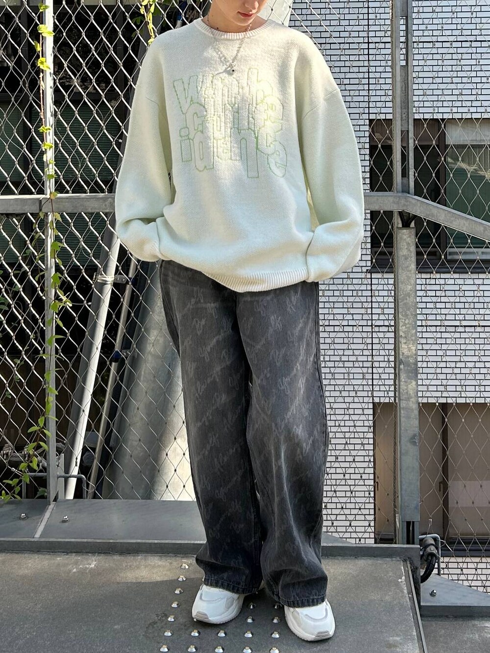 ブラック系のデニムパンツ、ホワイト系のニット/セーター、ブラック系のニットキャップ/ビーニーを着用したレディースの冬コーディネートの3枚目の写真
