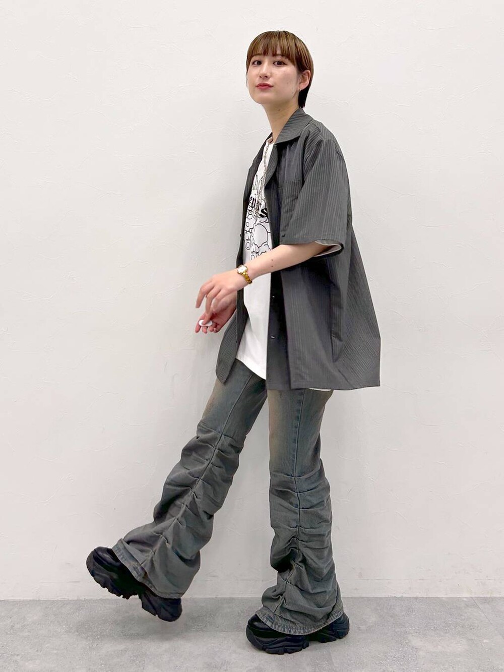 ブラック系のスニーカー、ホワイト系のTシャツ/カットソー、グレー系のシャツ/ブラウスを着用したレディースの夏コーディネートの3枚目の写真