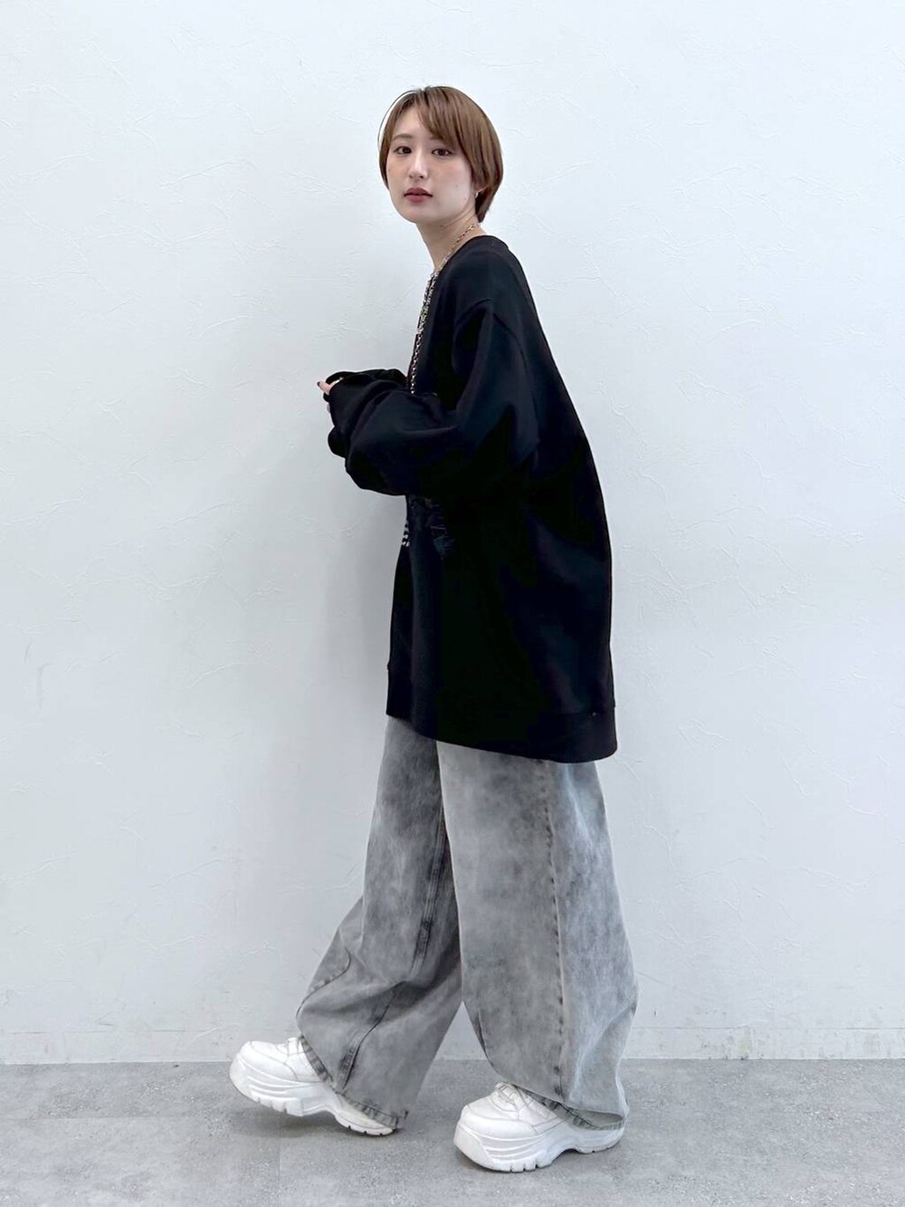 ブラック系のデニムパンツ、ブラック系のスウェット、シルバー系のネックレスを着用したレディースの夏コーディネートの2枚目の写真