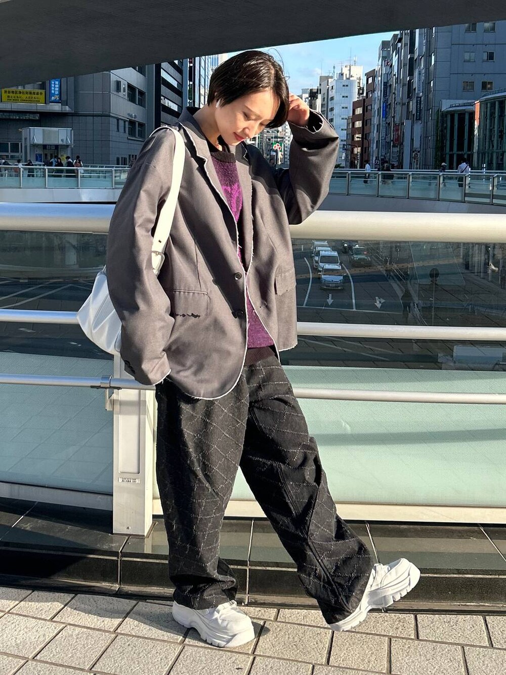 グレー系のテーラードジャケット、ブラック系のニット/セーター、ブラック系のデニムパンツを着用したレディースの冬コーディネートの4枚目の写真