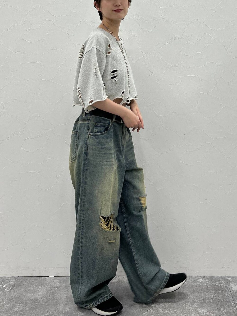 グレー系のTシャツ/カットソー、ブルー系のデニムパンツ、グリーン系のキャップを着用したレディースの秋コーディネートの6枚目の写真