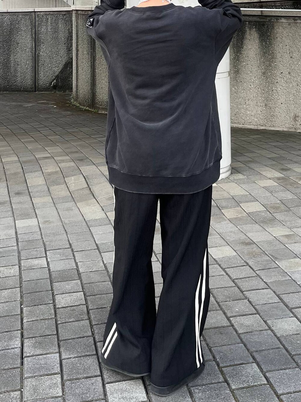 グレー系のスウェット、ブラック系のスラックス、ベージュ系のネックレスを着用したレディースの春コーディネートの7枚目の写真