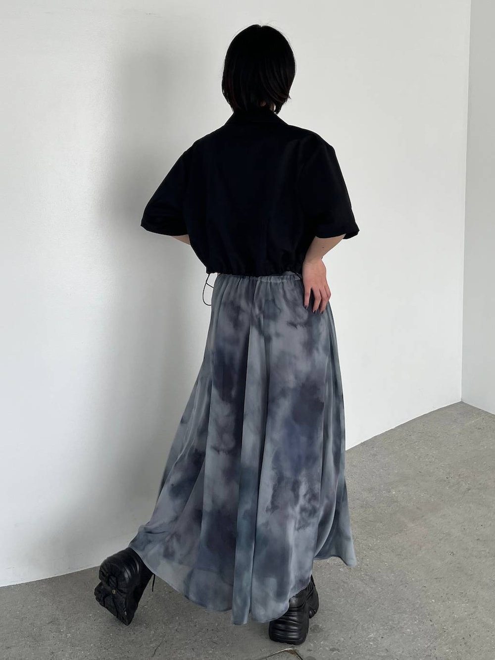 グレー系のスカート、ブラック系のスニーカー、ブラック系のキャミソールを着用したレディースの夏コーディネートの7枚目の写真