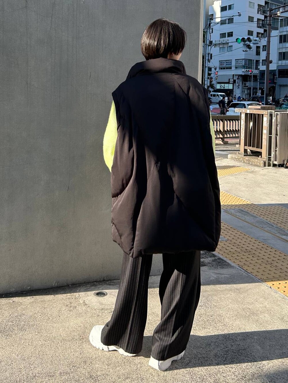 ブラック系のスラックス、ホワイト系のニット/セーター、ブラック系のブルゾンを着用したレディースの冬コーディネートの7枚目の写真